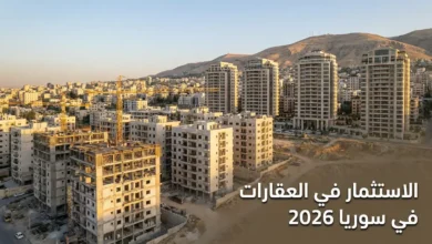 منظر بانورامي لمدينة دمشق يظهر مباني حديثة قيد الإنشاء مع رافعات بناء وأبراج سكنية مكتملة وجبل قاسيون في الخلفية مع نص الاستثمار في العقارات في سوريا 2026